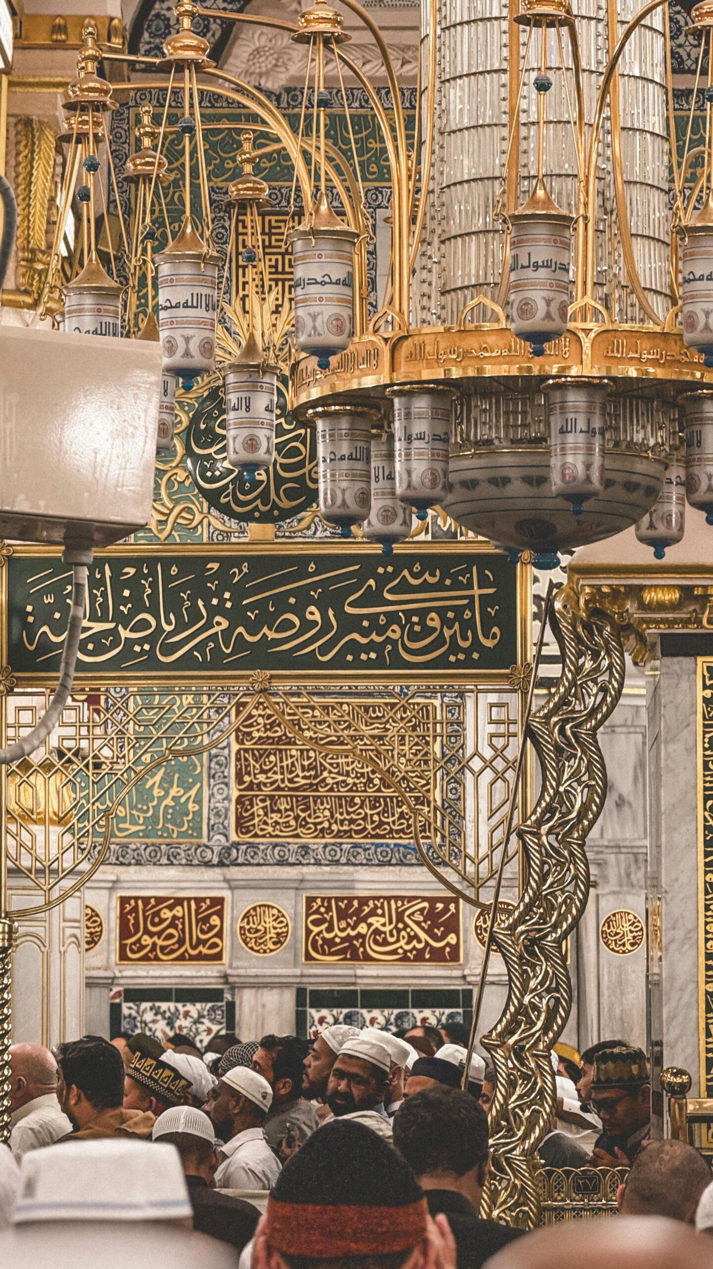 Stunning view inside Al Masjid an Nabawi featuring ornate chandeliers and Arabic calligraphy in Madinah, Saudi Arabia.